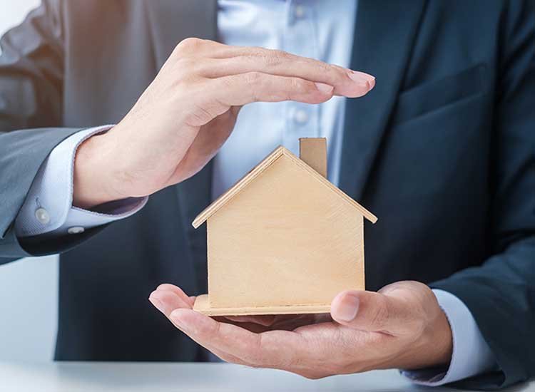 Hands holding a small wooden house model